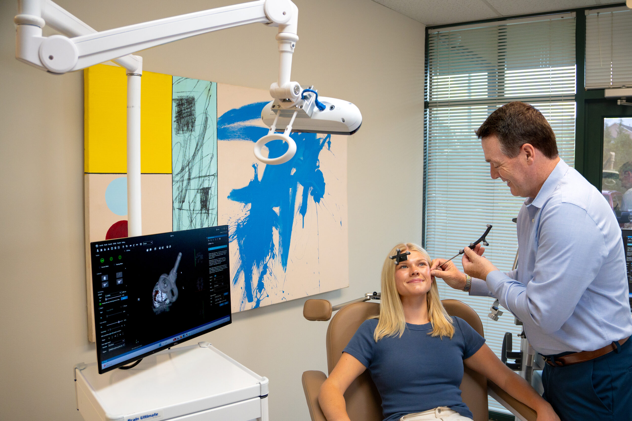 A clinician uses a tracked calibration pointer to map reference coordinates on the patient's head, with the 3D head model shown on the navigation display.